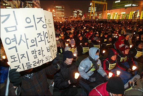 촛불대행진 참가자가 김원기 국회의장의 직권상정을 촉구하는 피켓을 들고 있다. 